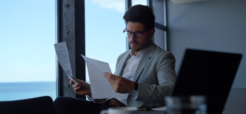 Empresário organizando documentos e planejando a migração do MEI para ME.