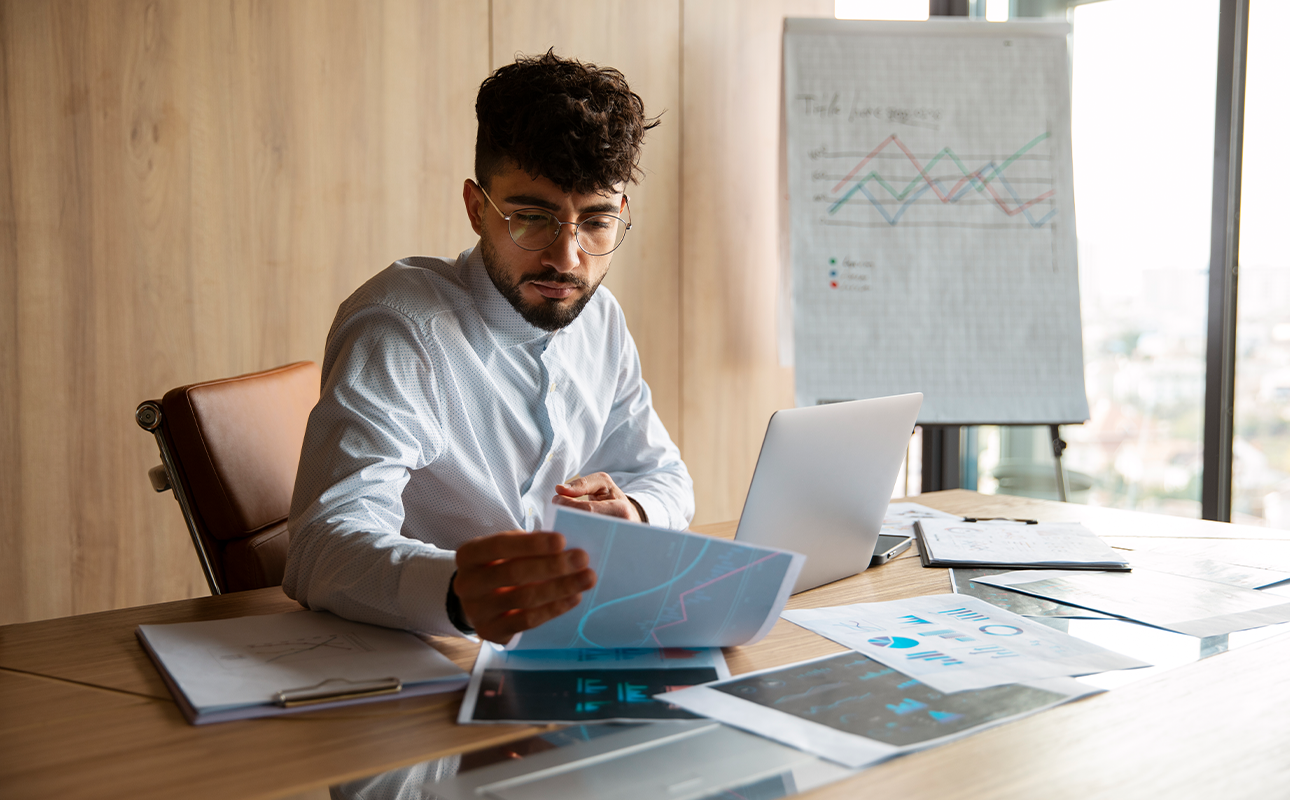 Empreendedor analisando planilhas distintas para contas pessoais e empresariais.